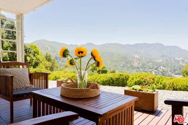 a view of a balcony with two chairs and a table