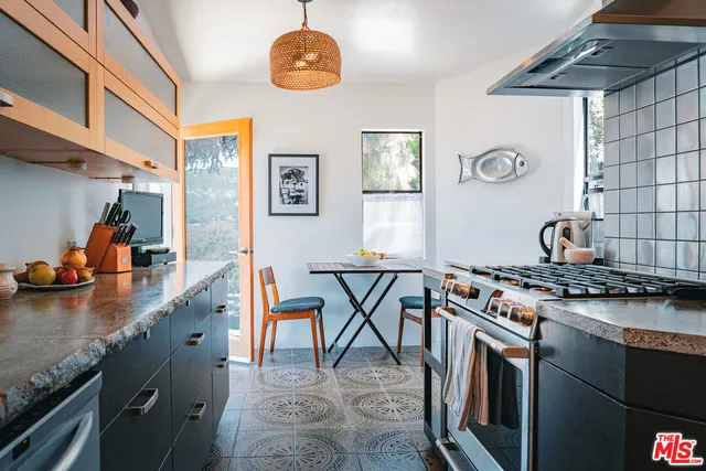 a kitchen with stainless steel appliances granite countertop a stove a sink dishwasher and cabinets with wooden floor