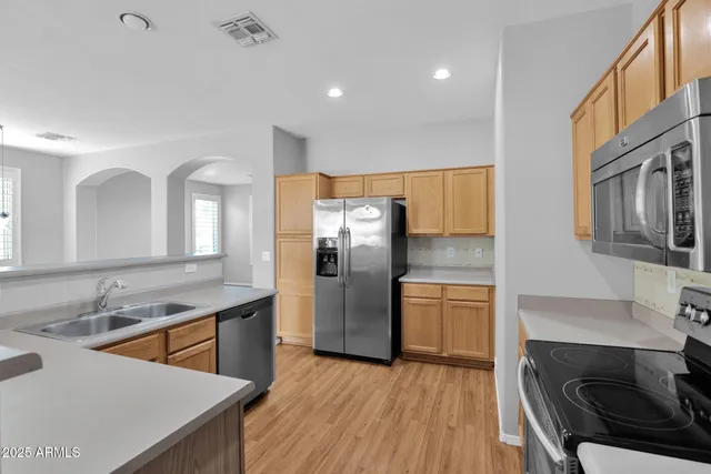 a kitchen with stainless steel appliances granite countertop a sink stove and refrigerator