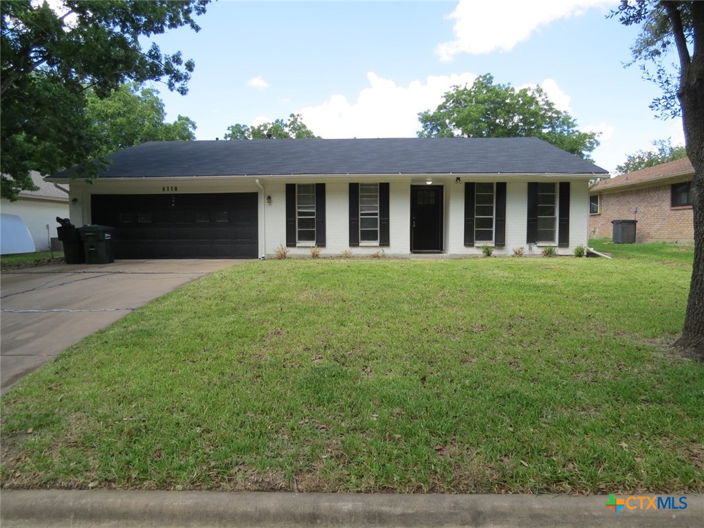 a front view of a house with a garden and yard