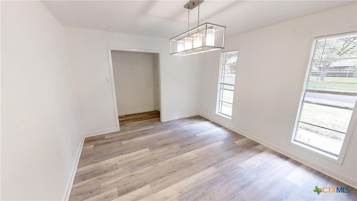 4118 Ermine Trail Temple, TX 76504 - Photo 5 of 31 an empty room with wooden floor cabinet and windows