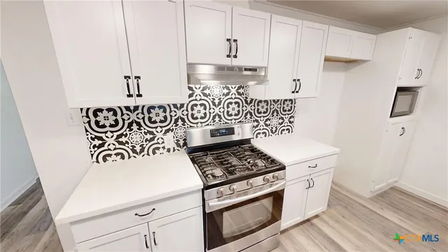 a kitchen with white cabinets and white appliances