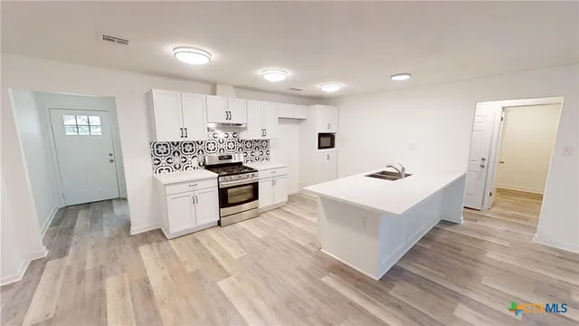 a view of kitchen with sink and refrigerator