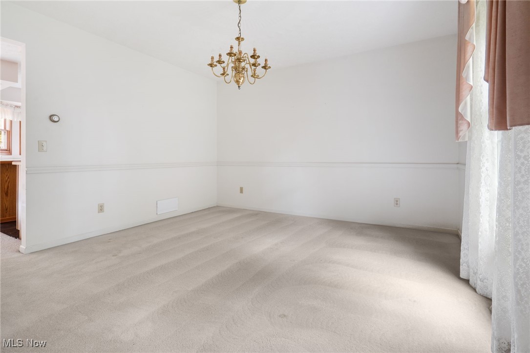 4057 Etter Road Mogadore, OH 44260 - Photo 11 of 41 Spare room featuring light colored carpet and an inviting chandelier