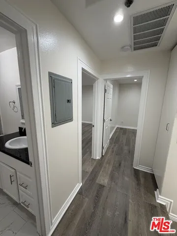 an empty room with wooden floor and entrance