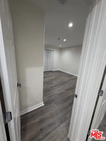 an empty room with wooden floor and window