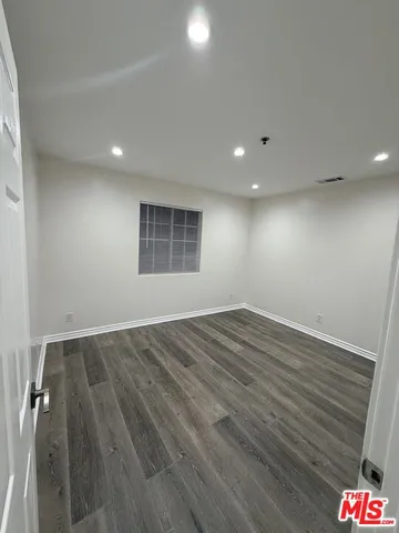 an empty room with wooden floor and cabinet