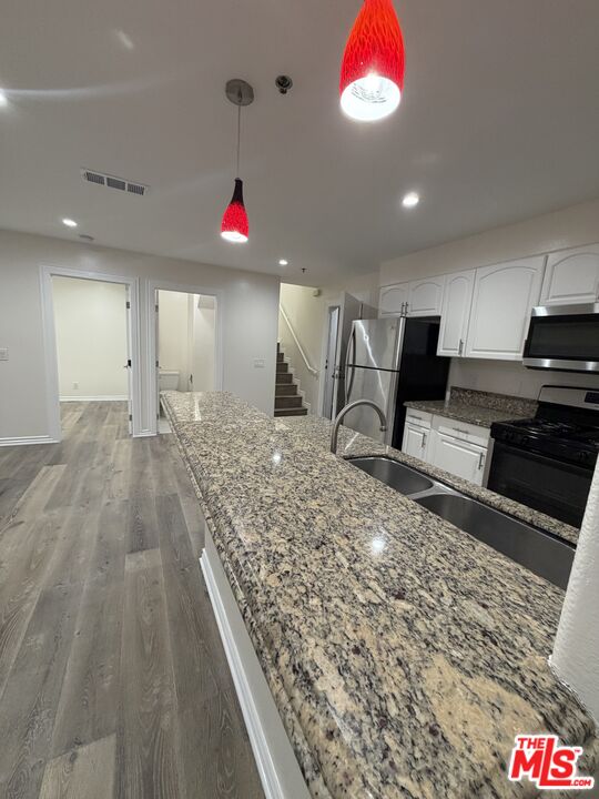 121 South Rampart Boulevard, Unit 3 Los Angeles, CA 90057 - Photo 2 of 20 a very nice looking open kitchen with granite countertop a stove a sink a window and a refrigerator