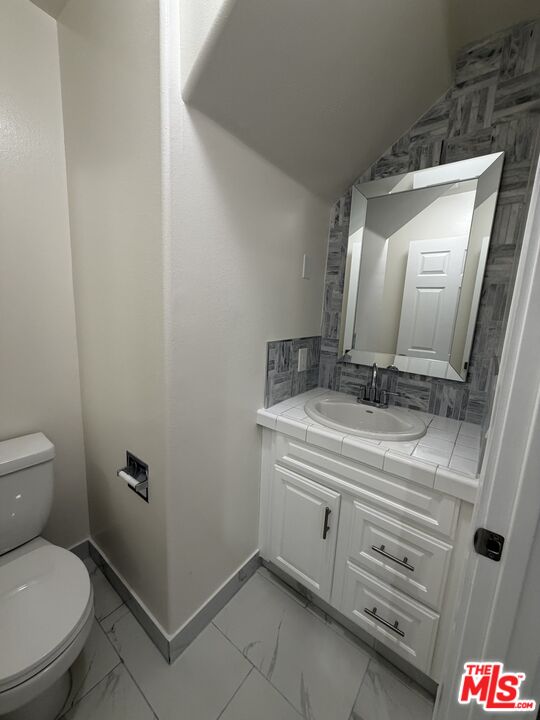 121 South Rampart Boulevard, Unit 3 Los Angeles, CA 90057 - Photo 6 of 20 a bathroom with a toilet sink and mirror