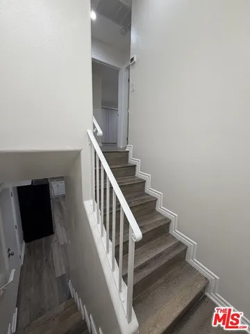 a view of a hallway with wooden floor and cabinet