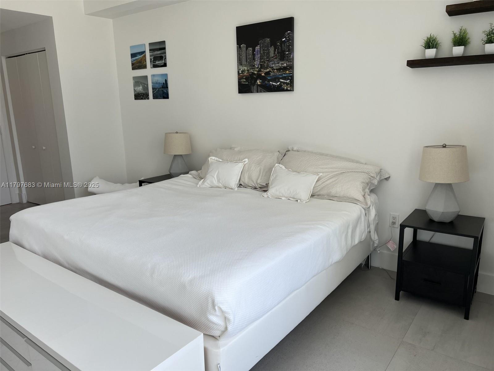 90 Southwest 3rd Street, Unit 1514 Miami, FL 33130 - Photo 18 of 25 a large bed sitting in a bedroom and a lamp