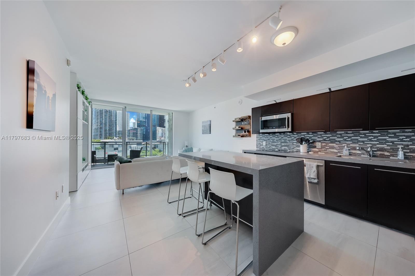 90 Southwest 3rd Street, Unit 1514 Miami, FL 33130 - Photo 4 of 25 a large white kitchen with a table and chairs