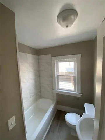 a bathroom with a sink toilet a mirror and bathtub
