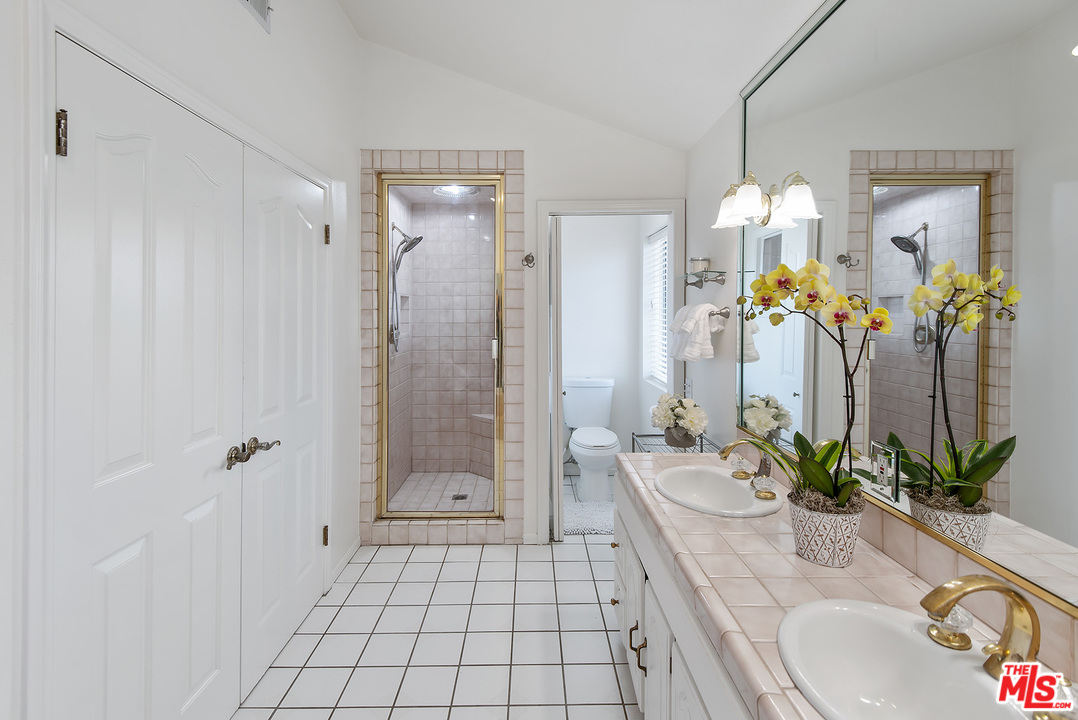 26021 Farmfield Road Calabasas, CA 91302 - Photo 35 of 50 a bathroom with a granite countertop sink a potted plant and a mirror