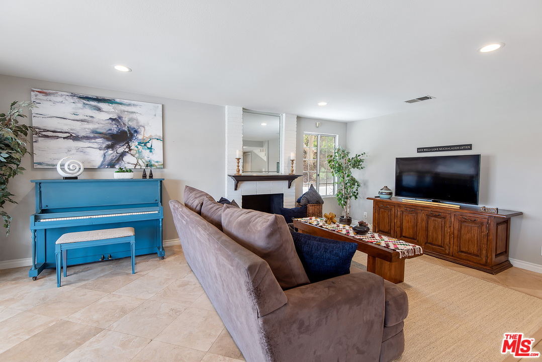 26021 Farmfield Road Calabasas, CA 91302 - Photo 9 of 50 a living room with furniture a flat screen tv and a fireplace
