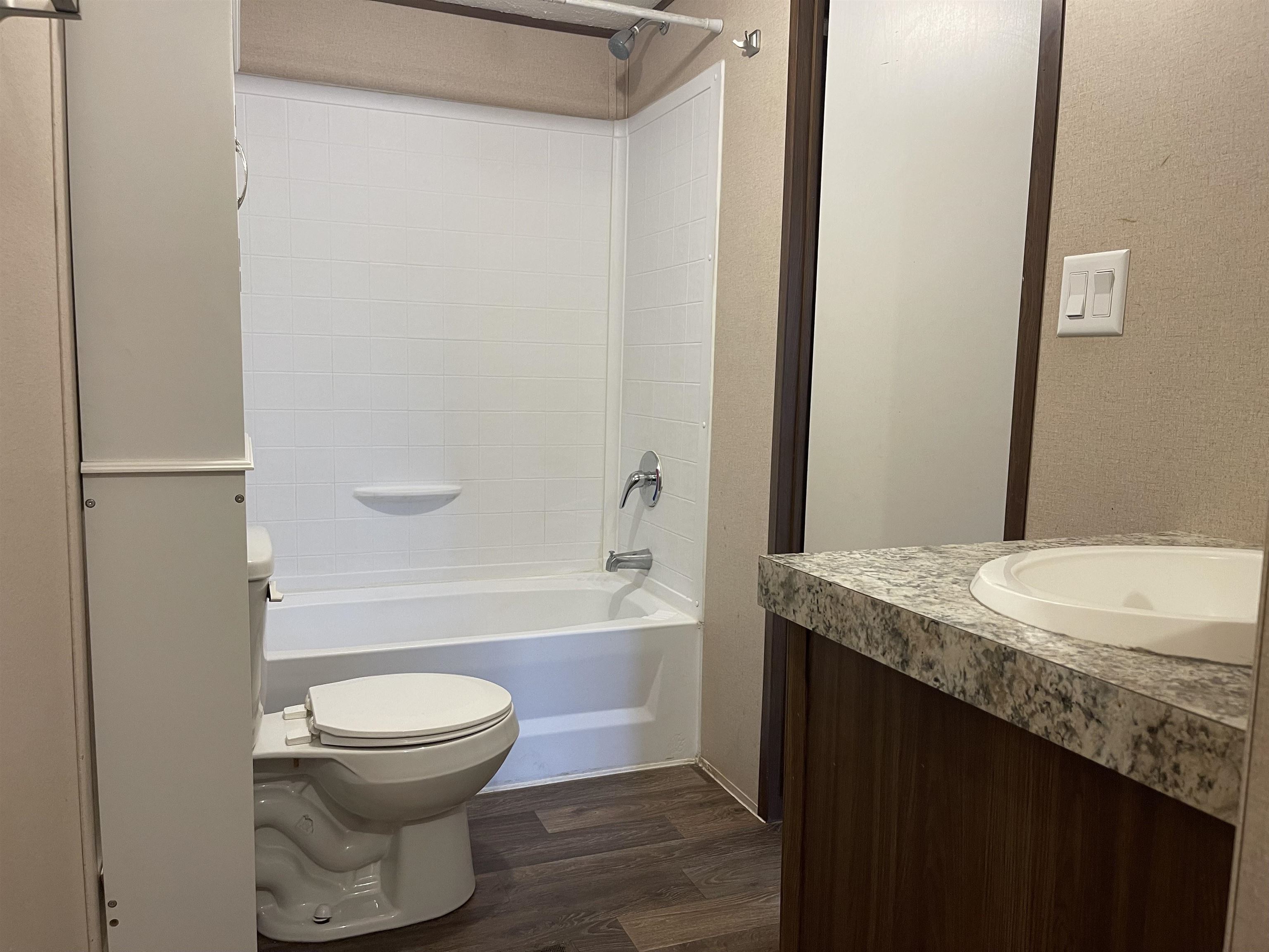 802 East Collins Street Llano, TX 78643 - Photo 10 of 14 a bathroom with a granite countertop sink toilet and shower