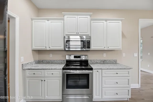 a kitchen with stainless steel appliances granite countertop a sink and refrigerator