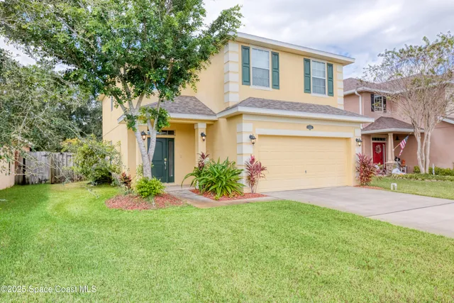 a front view of a house with a garden and plants