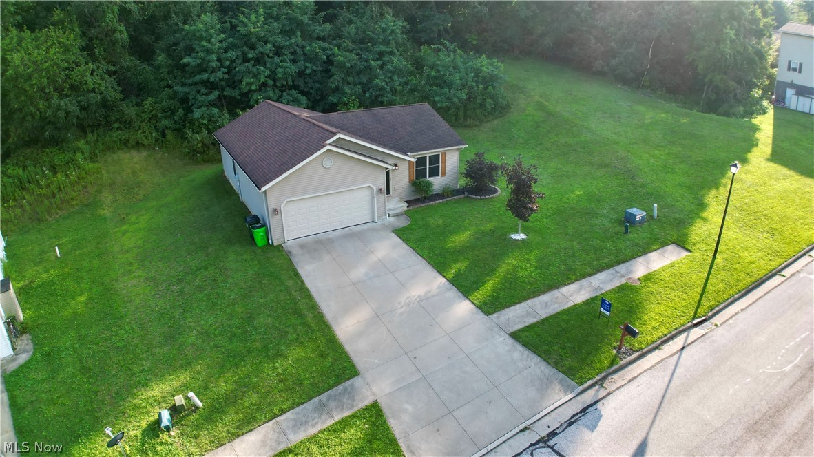 202 Home Street Rittman, OH 44270 - Photo 23 of 23 Ranch-style exterior with an attached garage, concrete driveway, and mature landscaping