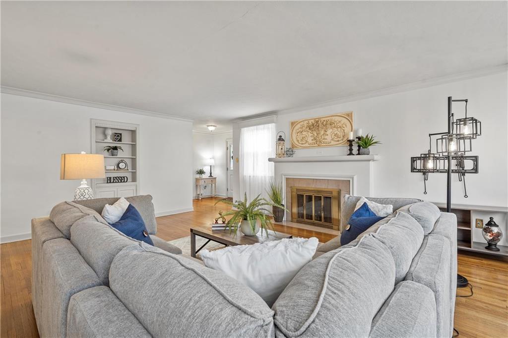 100 Circle Drive Pittsburgh, PA 15237 - Photo 7 of 31 a living room with furniture a fireplace and a large mirror with wooden floor