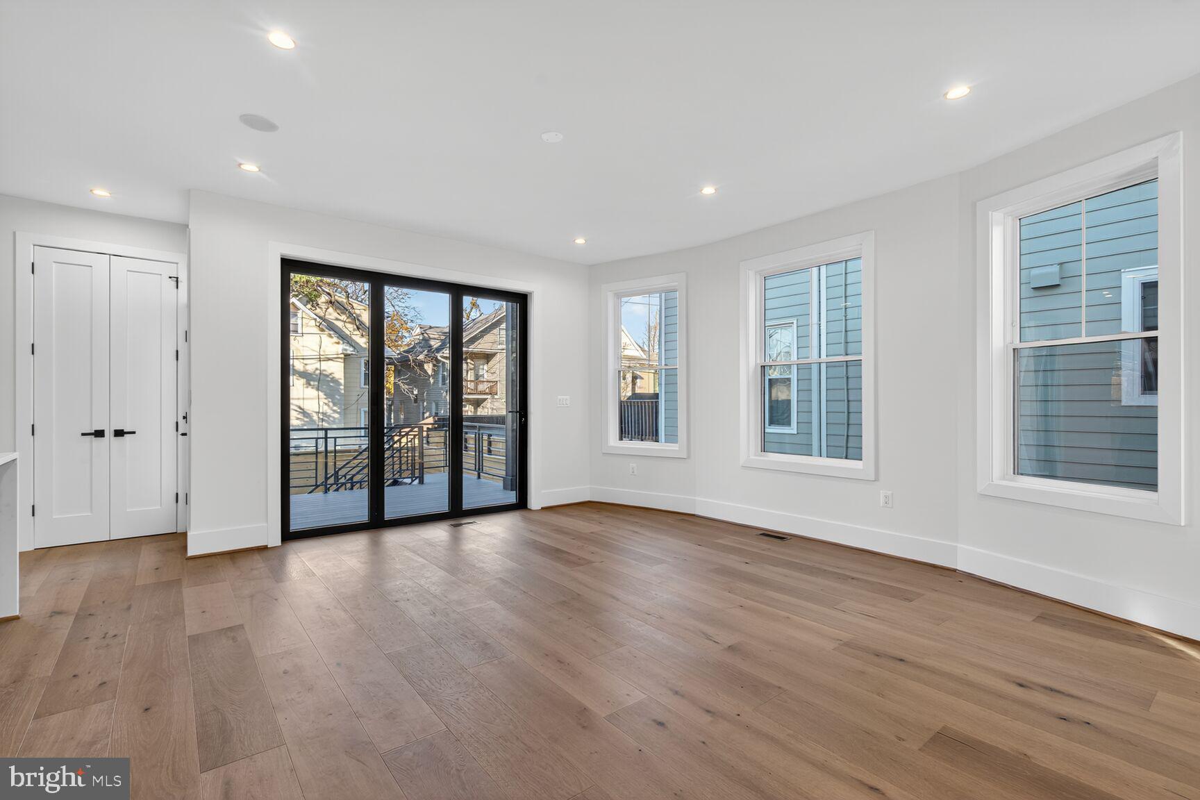 1209 Decatur Street Northwest Washington, DC 20011 - Photo 14 of 54 a view of an empty room with wooden floor and a window