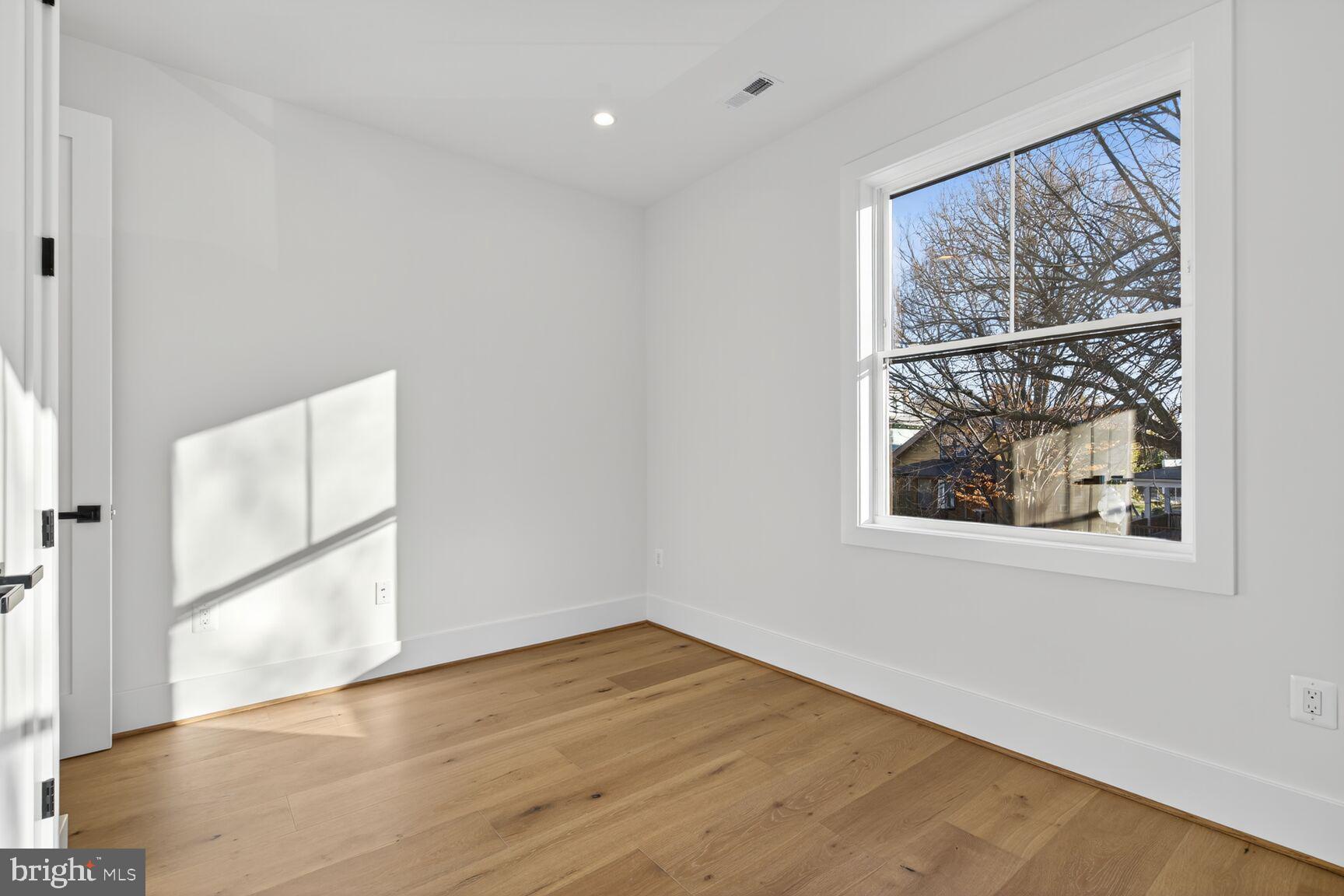 1209 Decatur Street Northwest Washington, DC 20011 - Photo 23 of 54 an empty room with wooden floor and windows
