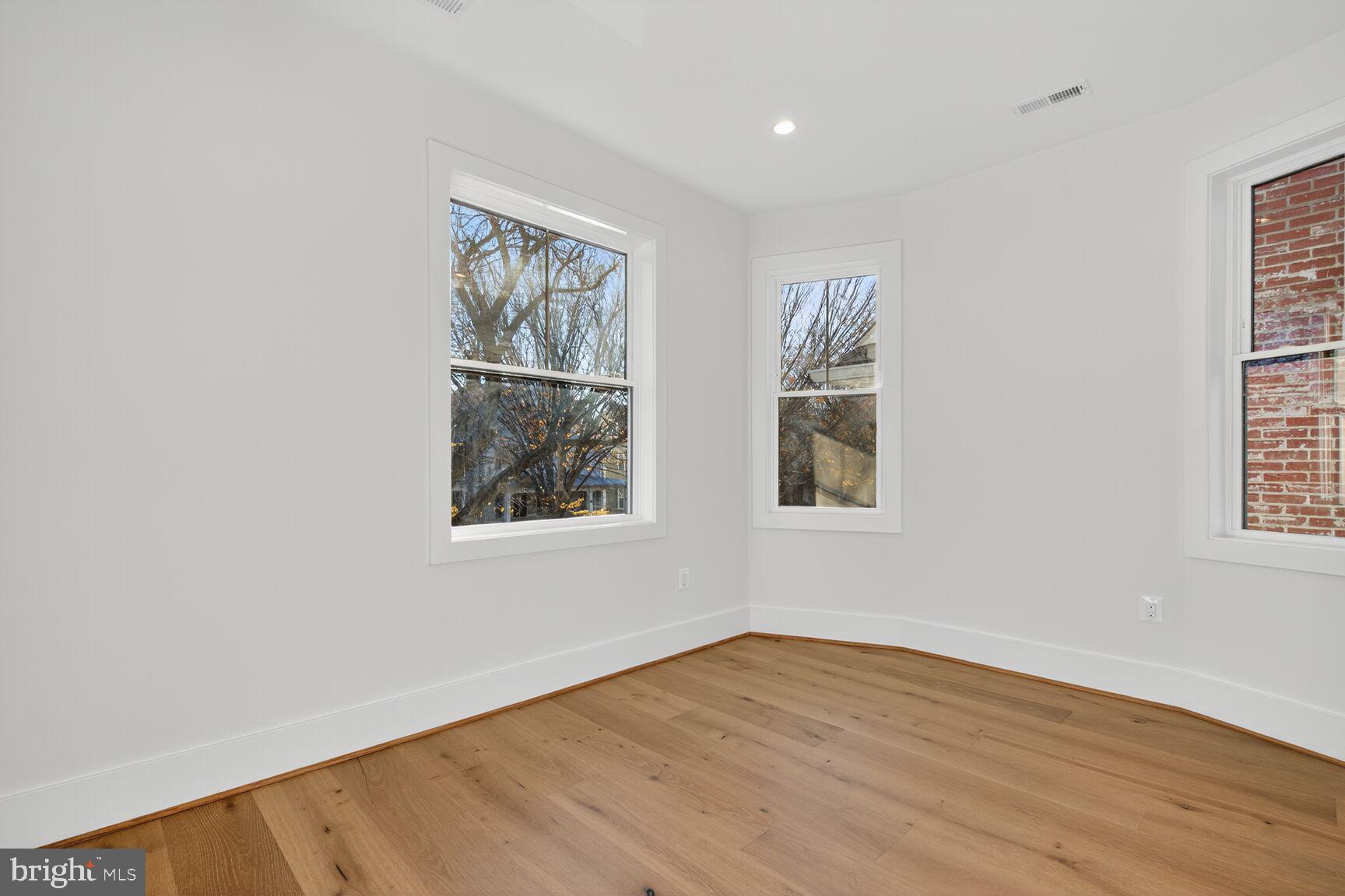 1209 Decatur Street Northwest Washington, DC 20011 - Photo 24 of 54 an empty room with wooden floor and windows