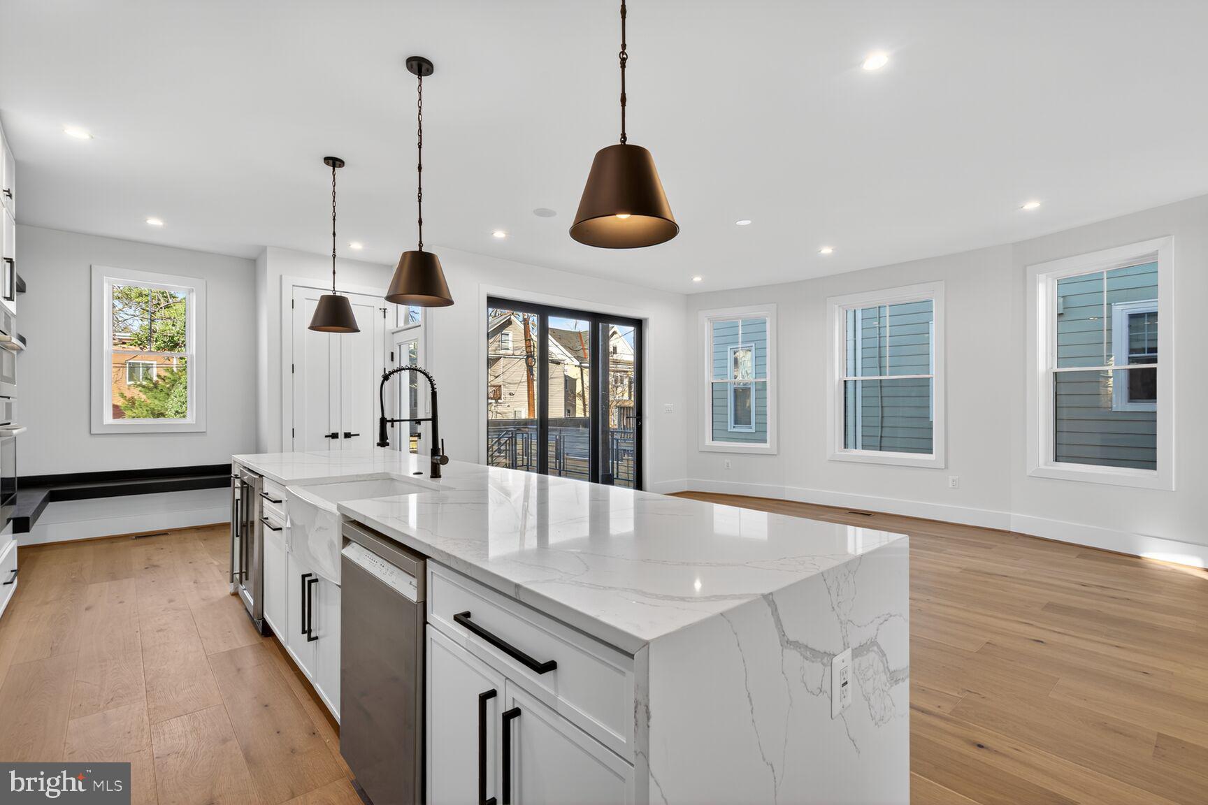 1209 Decatur Street Northwest Washington, DC 20011 - Photo 9 of 54 a large kitchen with stainless steel appliances granite countertop a sink a window and wooden floor