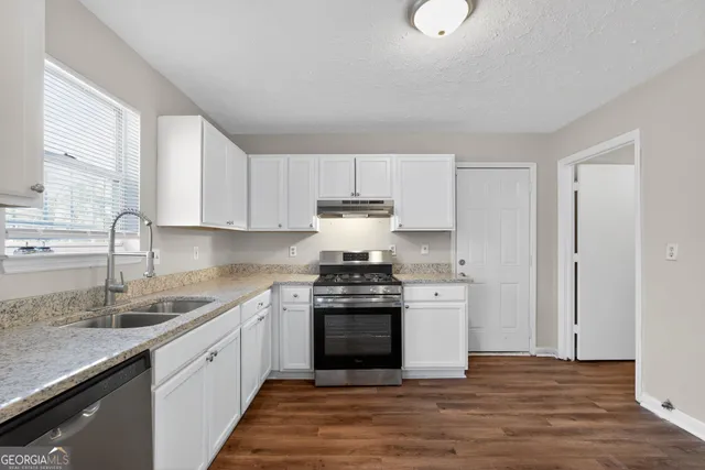 a kitchen with stainless steel appliances granite countertop a stove and a sink