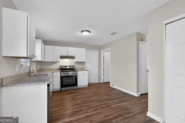 a kitchen with granite countertop a stove top oven and sink