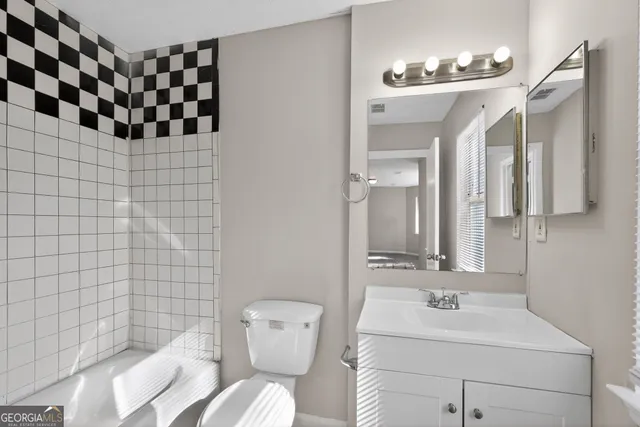 a bathroom with a sink mirror and toilet