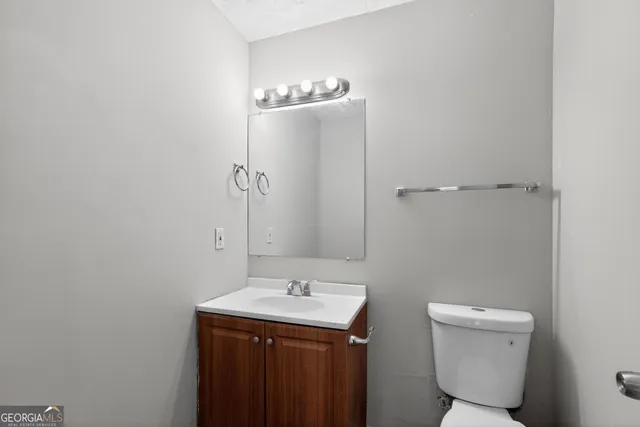 a bathroom with a sink a toilet and mirror