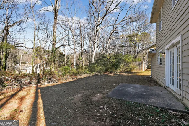 a view of a yard with plants and trees