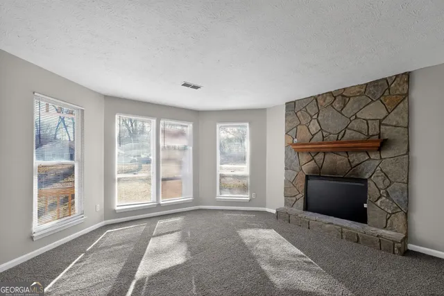 a view of an empty room with a fireplace and a window