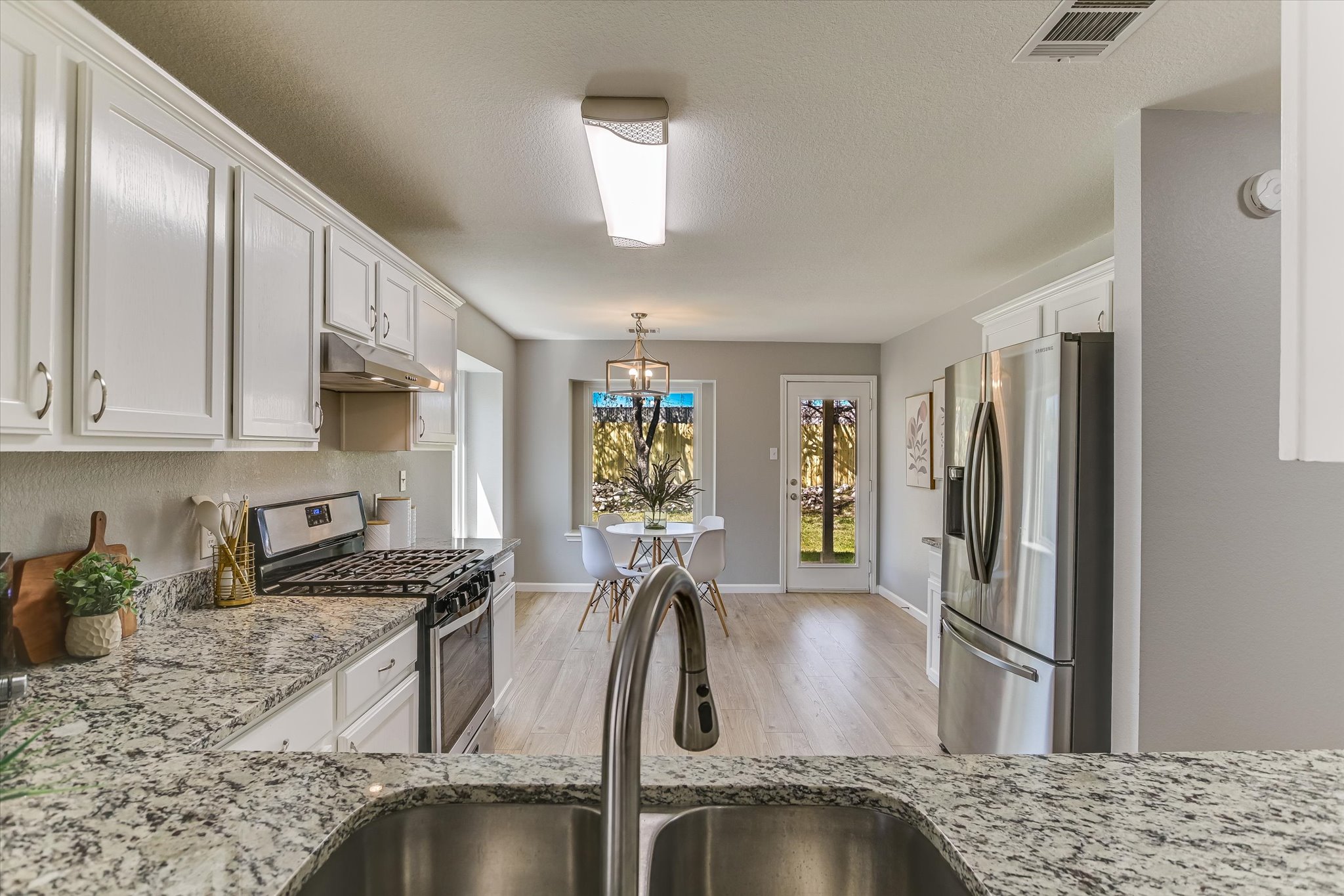 1520 Miss Allison's Way Pflugerville, TX 78660 - Photo 9 of 20 a kitchen with stainless steel appliances granite countertop a sink refrigerator and microwave
