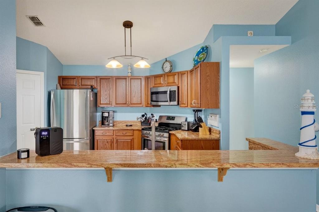 630 Fawn Ridge Drive Orange City, FL 32763 - Photo 12 of 55 a kitchen with stainless steel appliances granite countertop a sink refrigerator and microwave