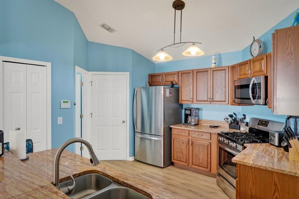 630 Fawn Ridge Drive Orange City, FL 32763 - Photo 13 of 55 a kitchen with stainless steel appliances granite countertop a refrigerator a sink dishwasher a stove and a dining table with wooden floor