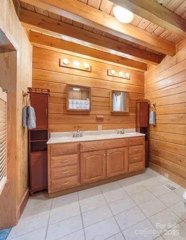 a bathroom with a granite countertop sink and washing machine