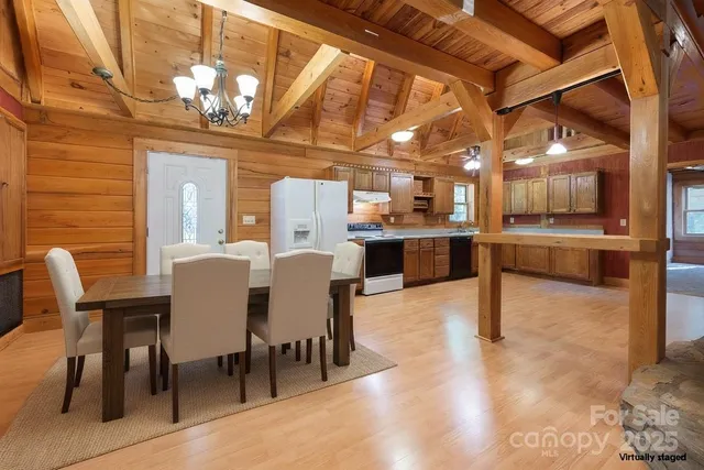 a view of a dining room with furniture a chandelier and wooden floor