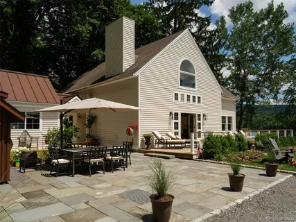 a view of a white house with a yard and sitting area