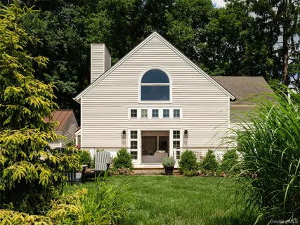 a front view of a white house with a yard and potted plants