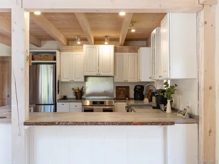 a kitchen with stainless steel appliances granite countertop a sink a stove and a refrigerator