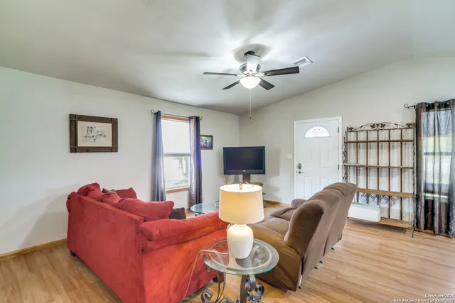 a living room with furniture a bookshelf and a flat screen tv