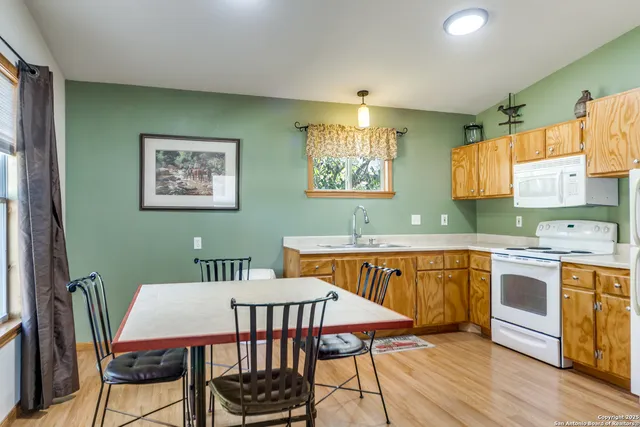 a view of a kitchen area with furniture and wooden floor