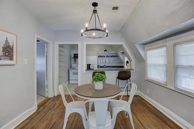 a view of a dining room with furniture a chandelier and wooden floor
