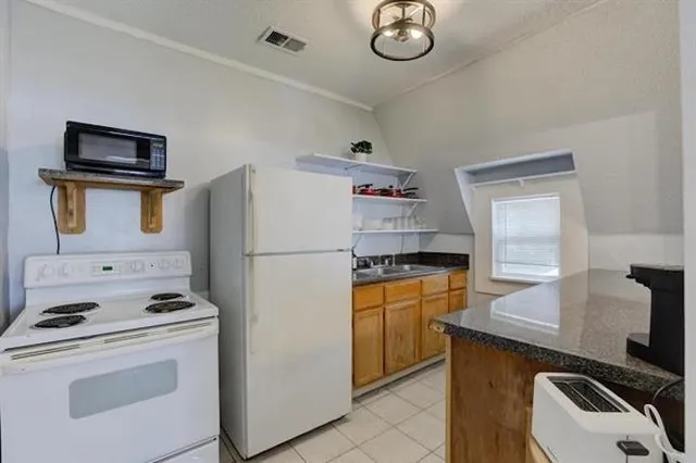 a kitchen with a refrigerator sink and stove top oven