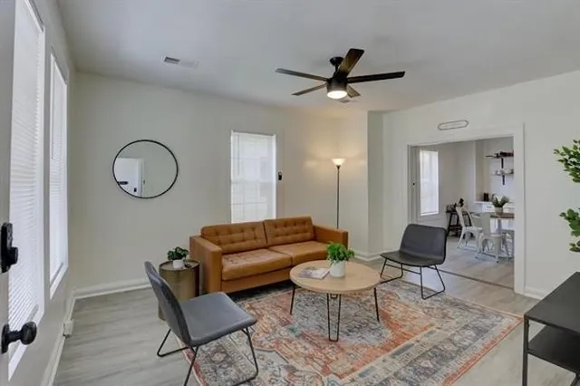 a living room with furniture a rug a lamp and a rug