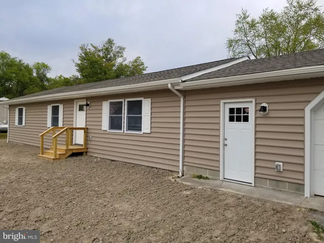 a backyard of a house with barbeque oven and seating space