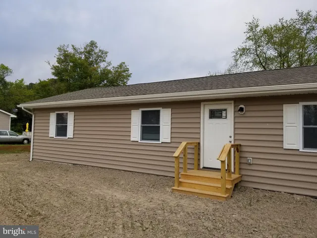 a view of a house with a yard and a large tree
