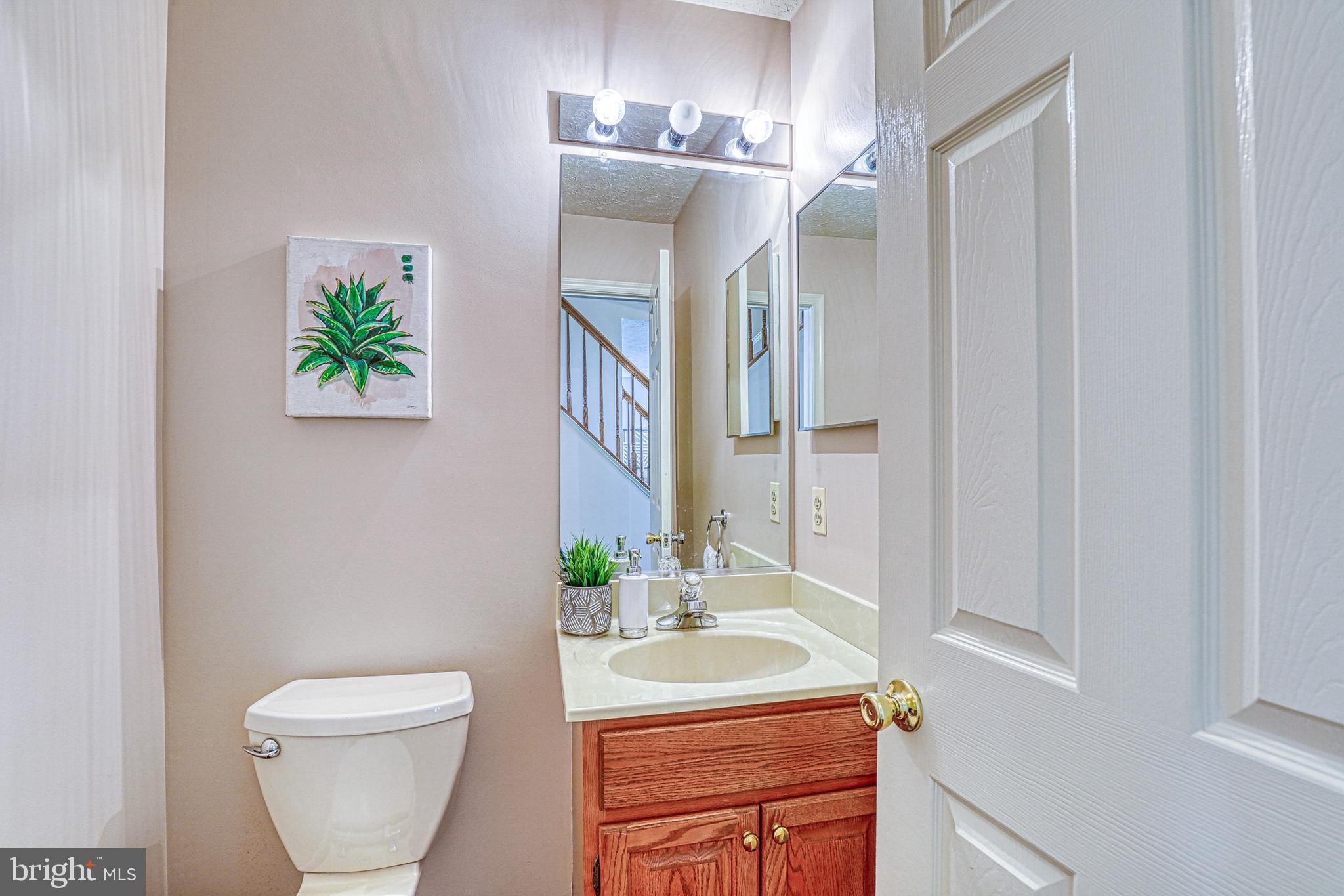 8235 Quarterfield Road Severn, MD 21144 - Photo 14 of 34 a bathroom with a sink a toilet and a mirror